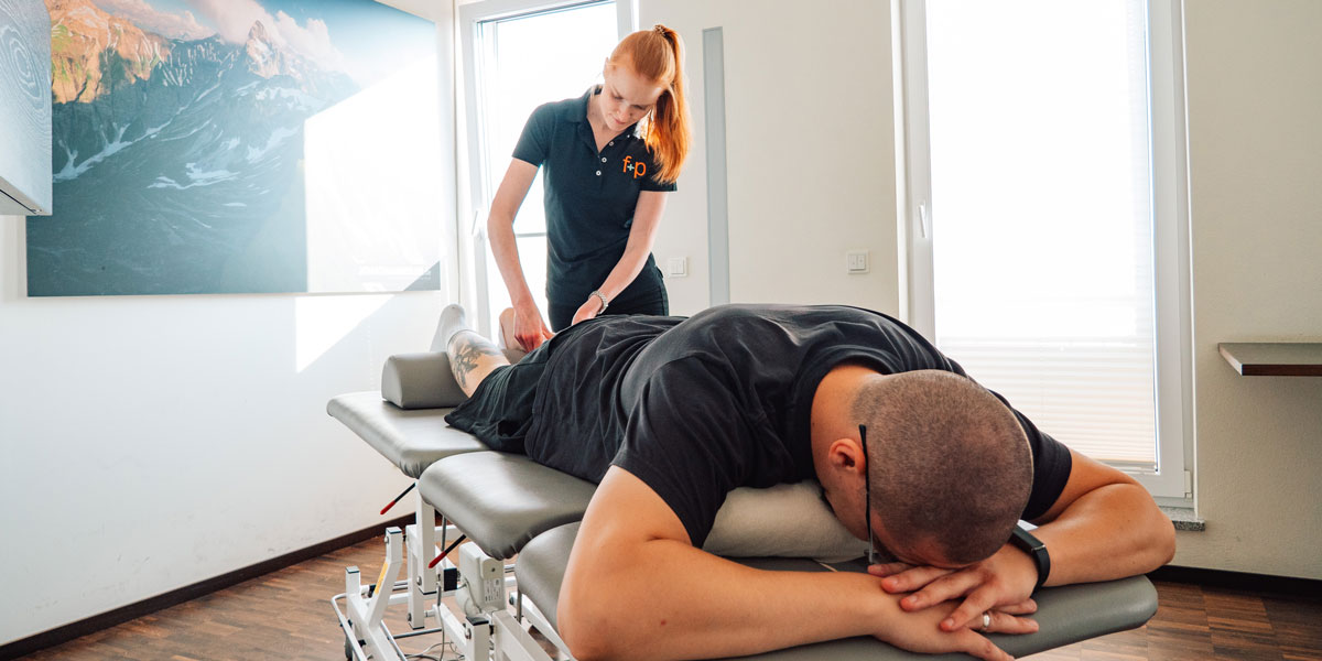 Eine Person erhält eine Lymphdrainage-Behandlung auf einer Liege in einem Behandlungsraum.