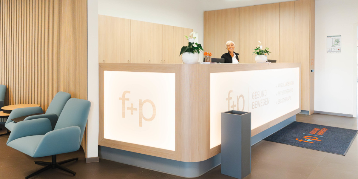 Empfangstresen in einer Rehabilitationsklinik mit einer Mitarbeiterin und modernen Möbeln.