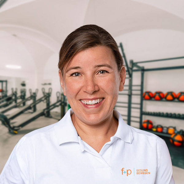 Heidi, Fachärztin für Orthopädie und Unfallchirurgie, in weißem Polohemd vor Trainingsräumen und medizinischer Ausrüstung bei f+p Gesund Bewegen im Allgäu