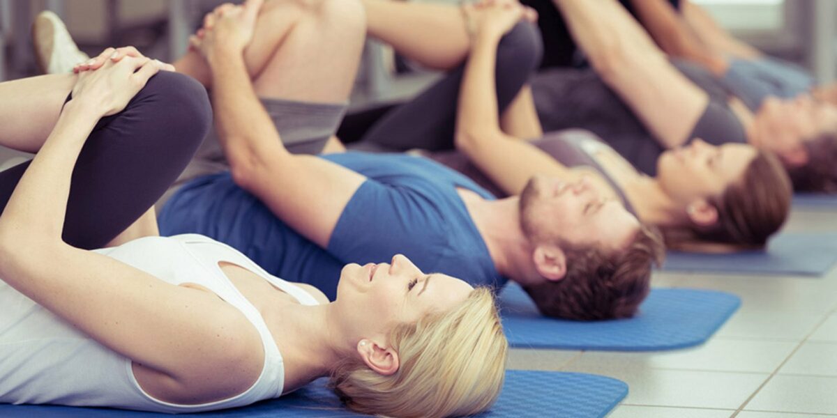 csm_Reha-Sport_b186b2ba0f Gruppentraining im Reha-Sport mit mehreren Personen, die auf Matten liegen und Übungen durchführen.