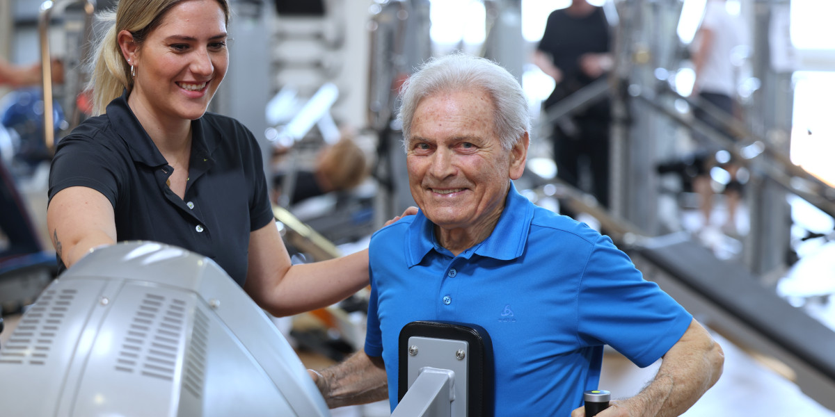 Ein älterer Mann nutzt ein Trainingsgerät im Fitnessstudio mit Unterstützung einer Trainerin.