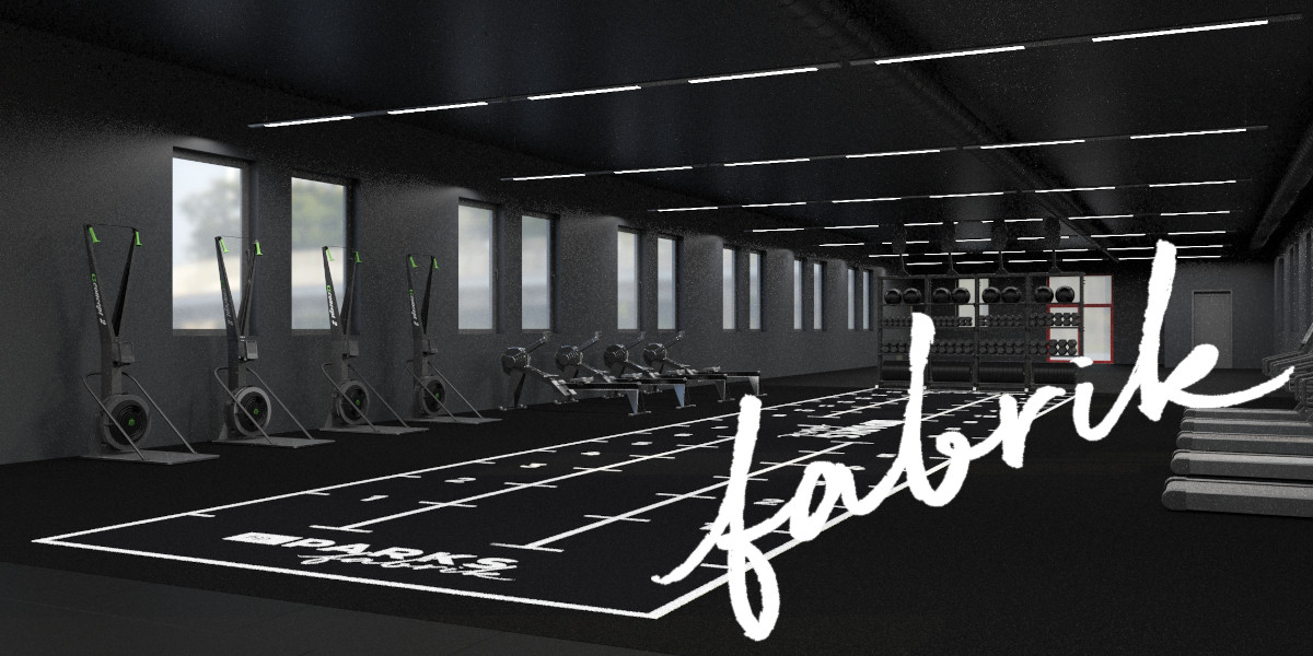 Innenansicht eines Fitnessstudios mit verschiedenen Trainingsgeräten und einem markierten Trainingsbereich.