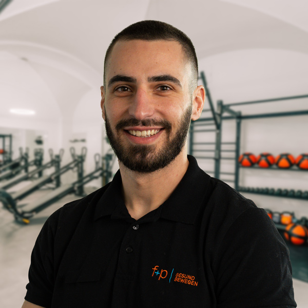 Mann mit Bart und kurzem Haar in schwarzem Poloshirt mit Logo von f+p Gesund Bewegen.