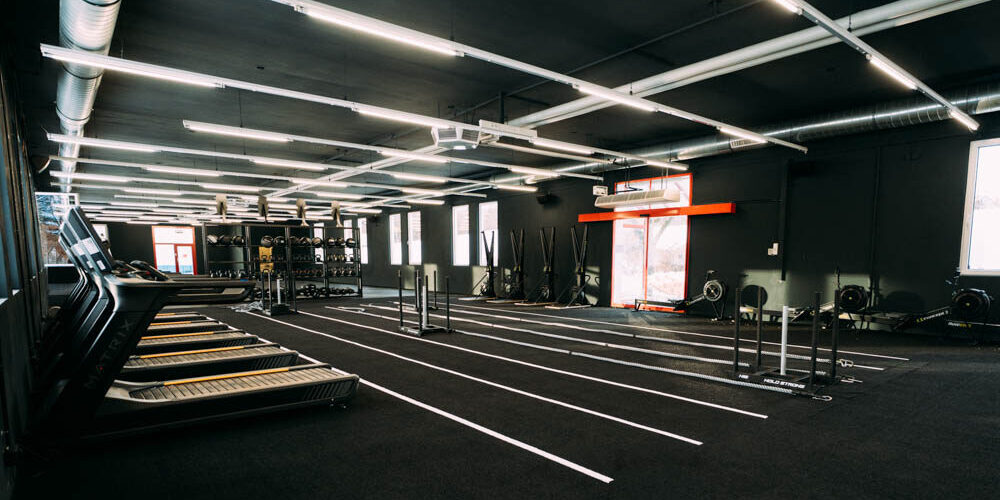 Moderne Fitnessstudio-Ausrüstung mit Laufbändern und Trainingsgeräten in einem gut beleuchteten Raum.