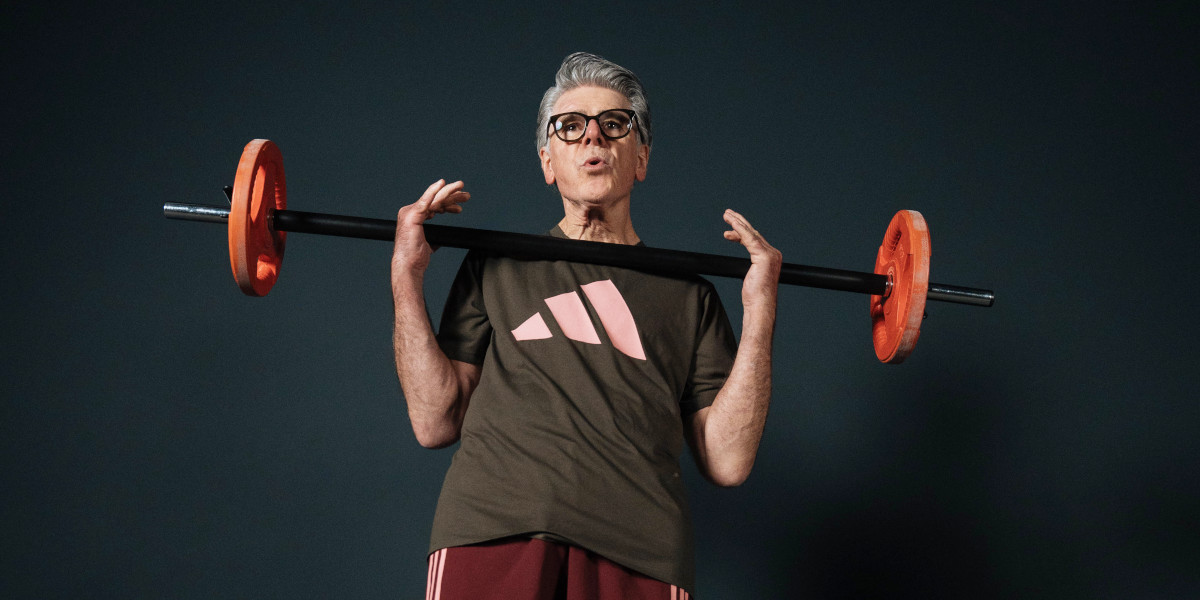 Krafttraining ab 40 mit RV Fit: Eine Person stemmt eine Langhantel über dem Körper, mit orangefarbenen Gewichten und dunklem Shirt.