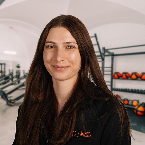 Porträt von Pia aus dem Bereich Ergotherapie bei f+p Gesund Bewegen vor Geräten und Trainingsmaterialien im Therapieraum